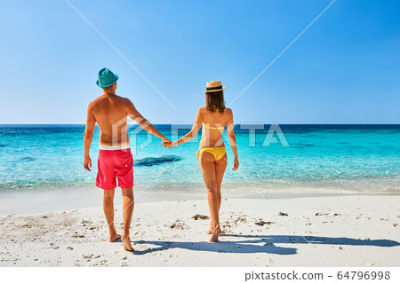 Couple walking on a tropical beach 64796998