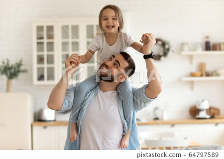 Cheerful dad carrying on neck happy little daughter. Cheerful dad carrying on neck happy little daughter. 64797589
