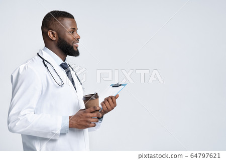 Friendly black male therapist holding medical chart and coffee 64797621