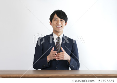 穿著西裝和另一個人說話的年輕人 64797825
