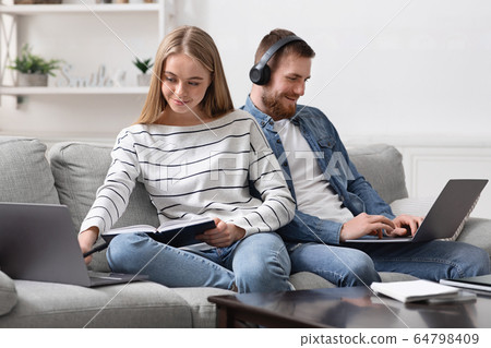Young couple spending time at home, studying and playing video games Young couple spending time at home, studying and playing video games 64798409