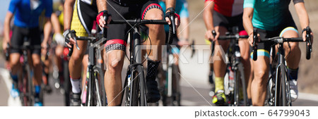 Cycling competition,cyclist athletes riding a race, the peloton climbing the mountain 64799043