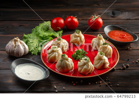 gedza with beef on a red plate and sauce in a cup gedza with beef on a red plate and sauce in a cup 64799213