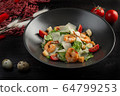 caesar salad with shrimp on a dark wooden background 64799253