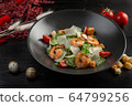 caesar salad with shrimp on a dark wooden background 64799256