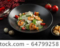 caesar salad with shrimp on a dark wooden background 64799258