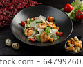 caesar salad with shrimp on a dark wooden background 64799260