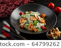 caesar salad with shrimp on a dark wooden background 64799262