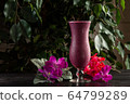 Cocktail with fruits and berries in a tall glass on a dark background 64799289