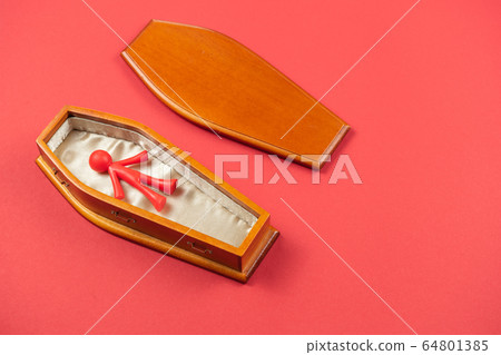 COVID-19 concept. Red bright coloured figurine in coffin COVID-19 concept. Red bright coloured figurine in coffin 64801385