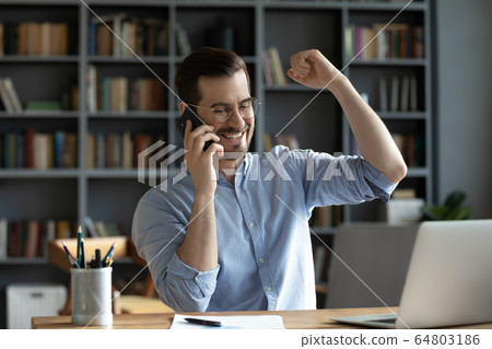 Smiling satisfied businessman making phone call, hearing good news 64803186