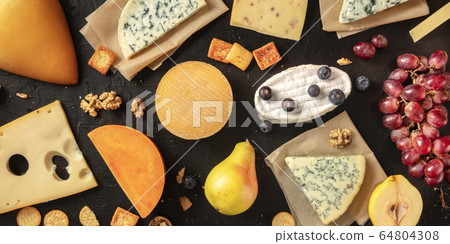 Cheese flat lay panorama. Many different cheeses, shot from above on a dark background Cheese flat lay panorama. Many different cheeses, shot from above on a dark background 64804308