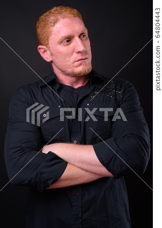 Portrait of muscular man with orange hair thinking with arms crossed Portrait of muscular man with orange hair thinking with arms crossed 64804443