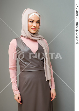 Beautiful woman in hijab and gray dress on an isolated background Beautiful woman in hijab and gray dress on an isolated background 64804476
