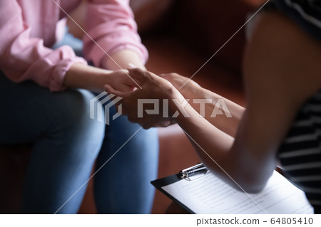 Female psychologist help support sad woman client at session 64805410