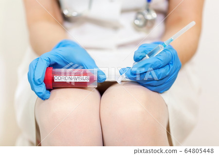 Woman Doctor holding Coronavirus COVID-19 Infected Blood Sample and syringe 64805448
