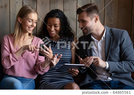 Multiracial couple relax on couch using gadgets Multiracial couple relax on couch using gadgets 64805561