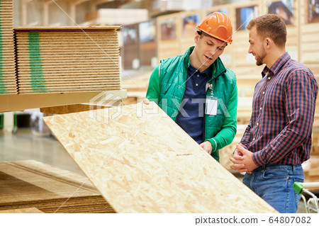 warehouse worker show the best variant of wooden board in their market 64807082