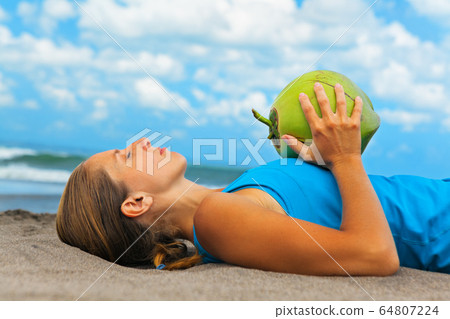 Woman fitness exercise with green coconuts on 64807224