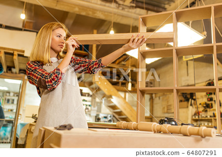 hardworking woodworker woman checking piece of wood hardworking woodworker woman checking piece of wood 64807291