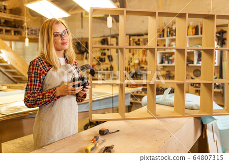 carpenter woman holding headphones carpenter woman holding headphones 64807315