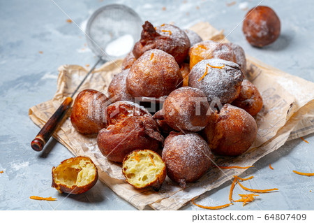 French doughnuts sprinkled with powdered sugar. 64807409