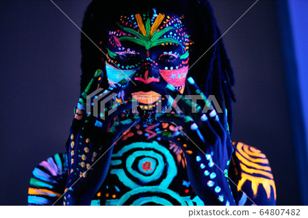 man in UV paint isolated, dark background man in UV paint isolated, dark background 64807482