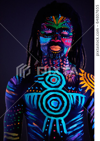 man in UV paint isolated, dark background man in UV paint isolated, dark background 64807655