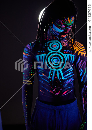 handsome african guy with fluorescent prints on chest and other parts of body 64807656
