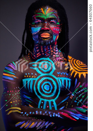 portrait of african man with ethnic pattern, neon makeup in ultraviolet light 64807660