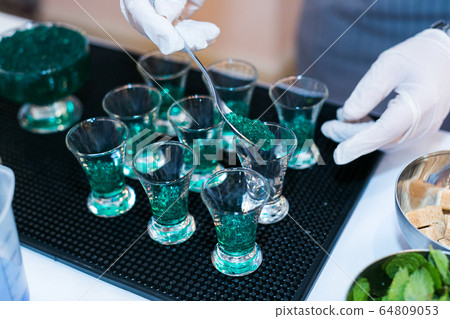 making a green caviar shot at molecular bar drink. 64809053