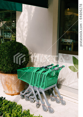 Supermarket trolleys. Green plastic trolleys from the supermarket. Supermarket trolleys. Green plastic trolleys from the supermarket. 64809278