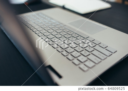 Gray laptop keyboard close up side view 64809525