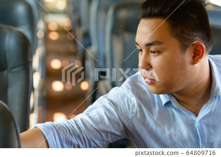 Young overweight Asian tourist man riding inside the train 64809716