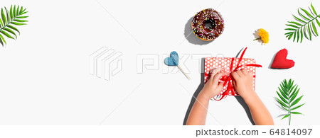 Little boy making a gift box Little boy making a gift box 64814097