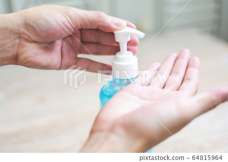 Women washing hands with alcohol gel or Women washing hands with alcohol gel or 64815964
