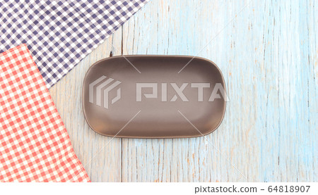 black plate on tablecloth on wood table background 64818907