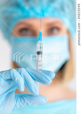 Syringe for injection in nurse hand. Medical glass 64819349