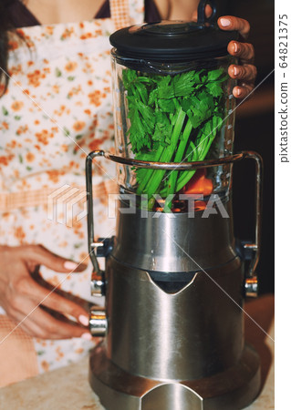 Staying at home woman using electric mixer to Staying at home woman using electric mixer to 64821375