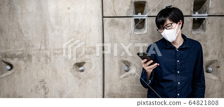 Asian man wearing mask using phone in subway 64821808