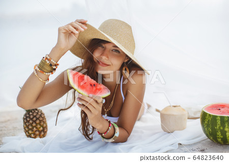 Woman on the Tropical Beach Eating Watermelon Woman on the Tropical Beach Eating Watermelon 64823640