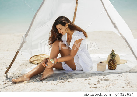 Woman Resting on the Beach During Vacation Woman Resting on the Beach During Vacation 64823654