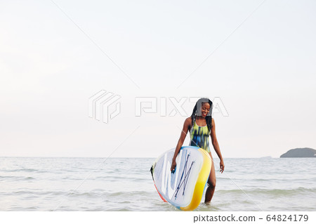 Surfer walking out of sea Surfer walking out of sea 64824179