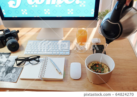 Freelance photographer having lunch at desk 64824270