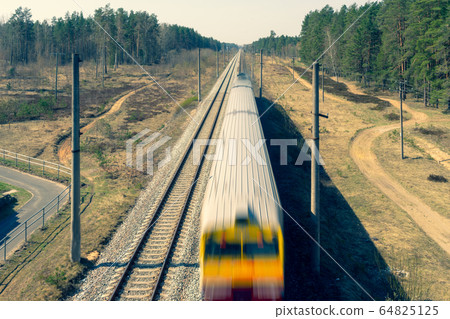 Electric train rides through the forest 64825125