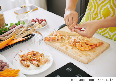 Housewife peeling boiled shrimps Housewife peeling boiled shrimps 64825212