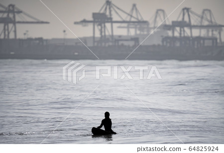 High contrast of unrecognizable surfer waiting for waves 64825924