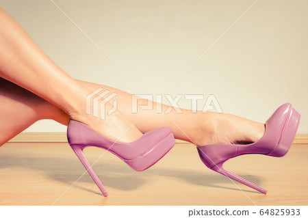 Purple high heels shoes on sexy female legs Purple high heels shoes on sexy female legs 64825933