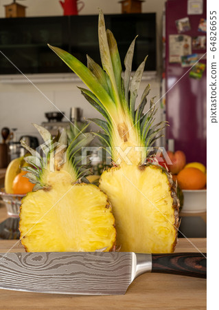Close-up view of two halve pineapple fruit and a Close-up view of two halve pineapple fruit and a 64826655