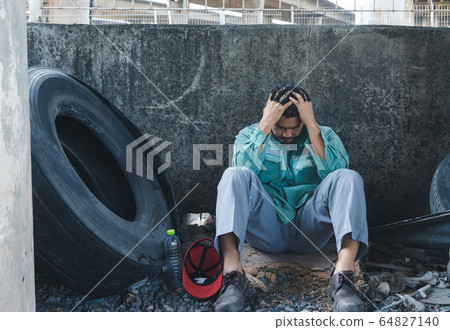 A man sitting by a wall 64827140